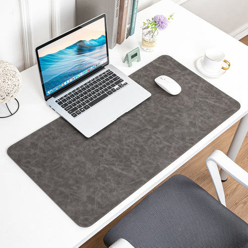 NOIRDEN premium gray leather desk mat styled with laptop and mouse on a minimal white desk